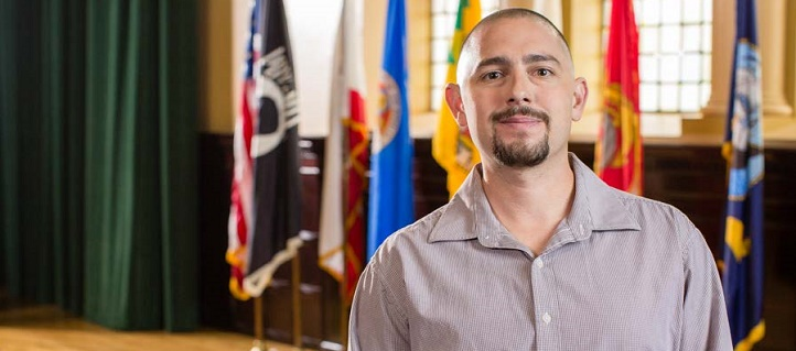 Man standing in front of military flags