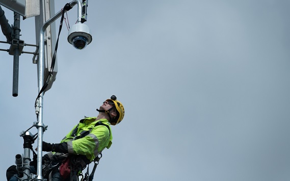 A lineman wearing a hard hat looking at the camera