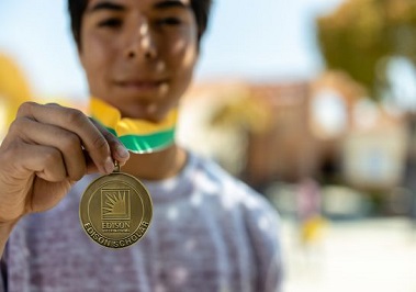 A young man showing off a medal