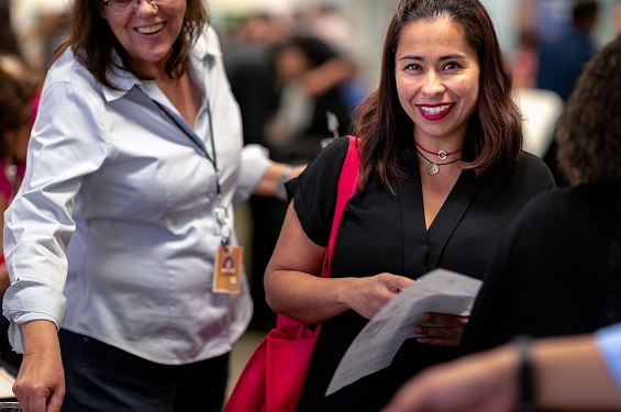 Two professional women in a business gathering type setting.