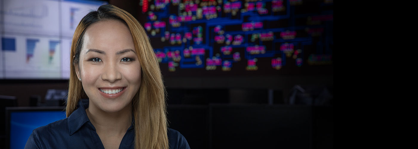A smiling woman with a grid board in the background