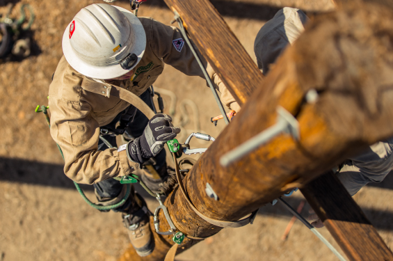A lineman climbing a pole