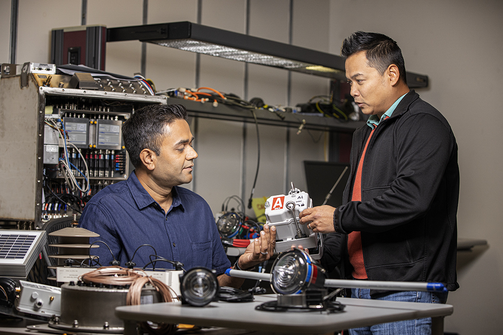 Two men looking at an electrical part