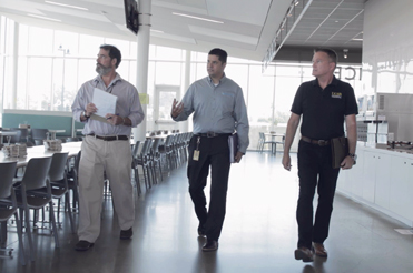 14840_5058_Planner2b Three men walking in a room looking towards the left