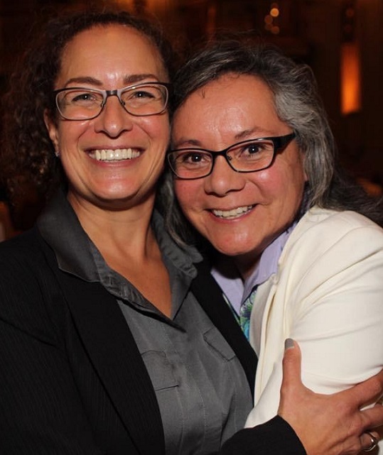 Two women smiling in an embrace