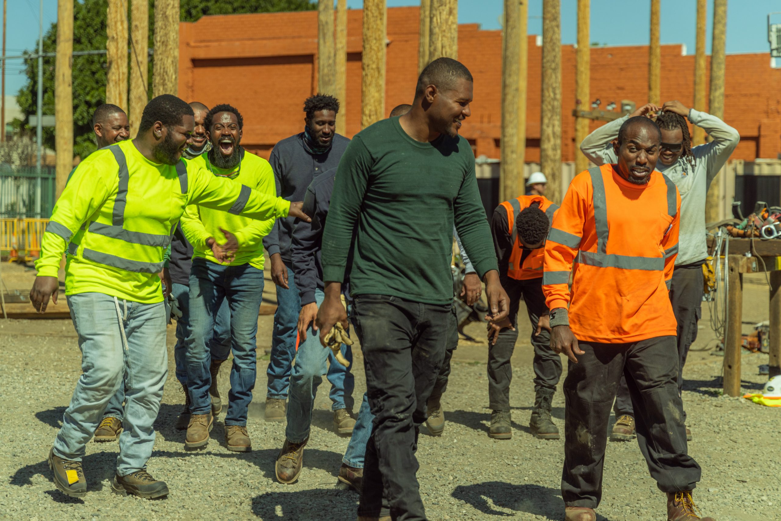 A group of lineman laughing and walking away from utility poles