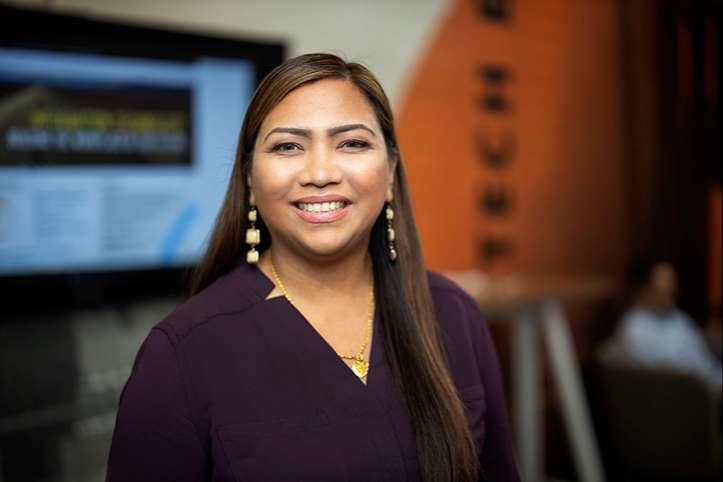 An SCE employee in a conference area smiling at the camera