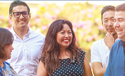 A group of SCE employees talking and laughing at an event