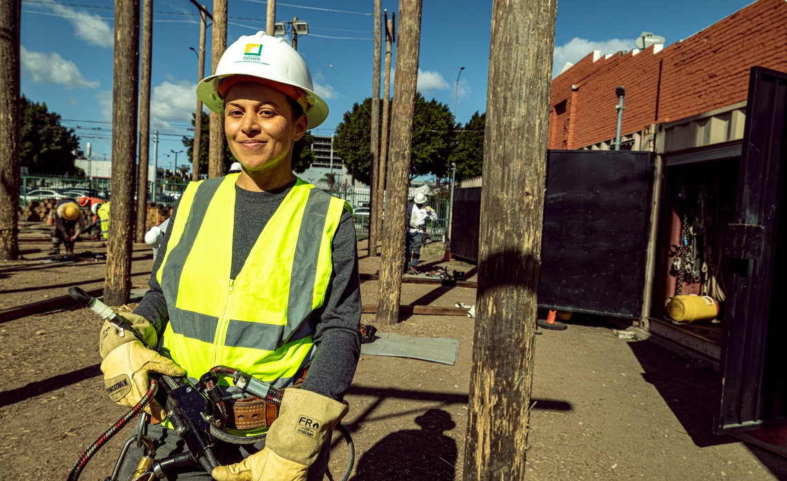 Woman in hard hat and working gear looking at the camera
